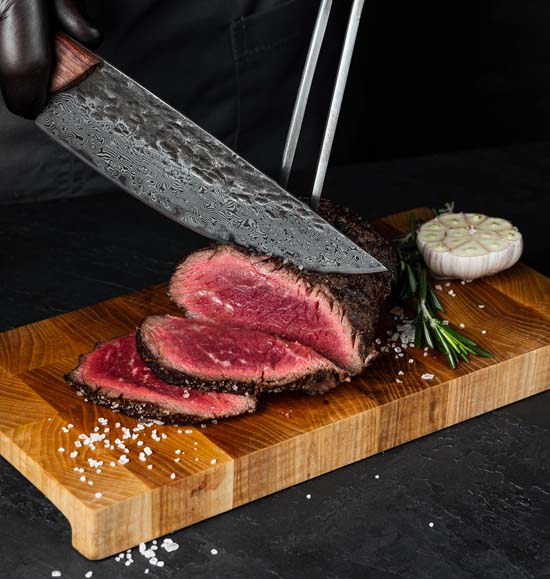 damascus chef knife slicing delicious meat